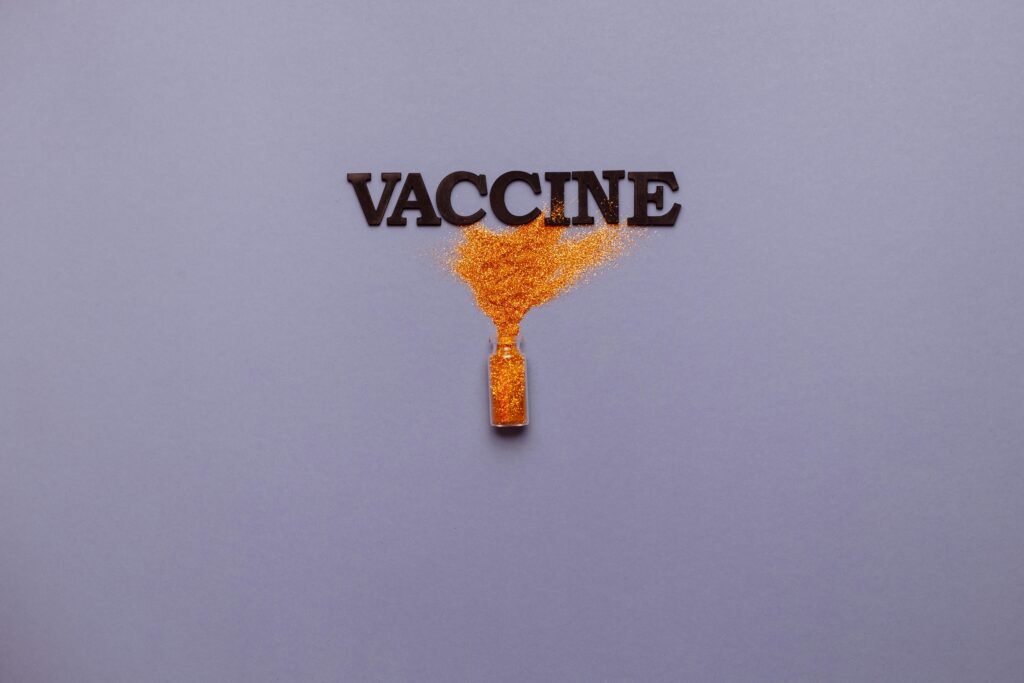 Conceptual image of Hepatitis B vaccine represented by glitter spreading from a vial forming the word 'VACCINE', symbolizing the importance of vaccination to prevent Hepatitis B.