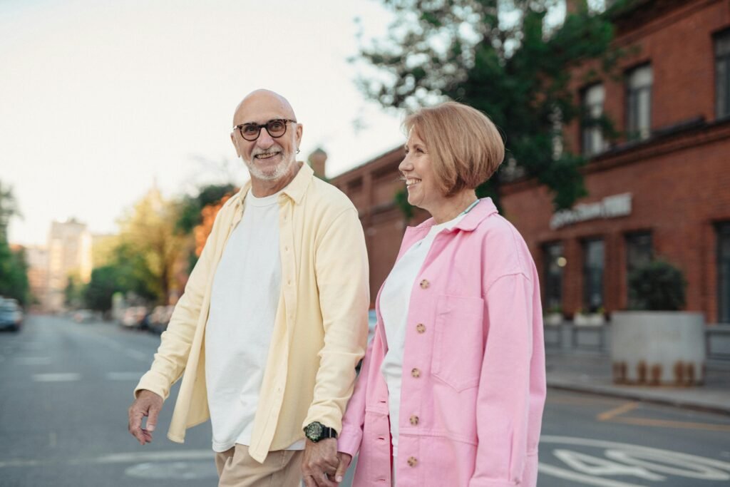 Senior couple walking outdoors and smiling — staying active as part of a heart-healthy lifestyle.