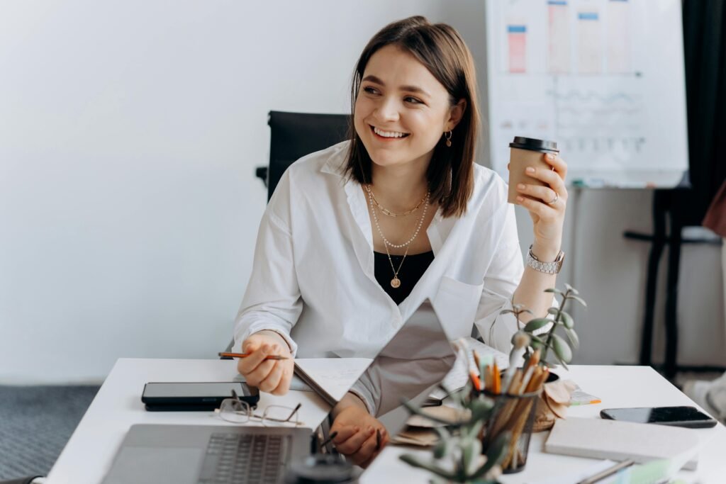 Professional woman smiling at workplace while managing stress for better work-life balance.